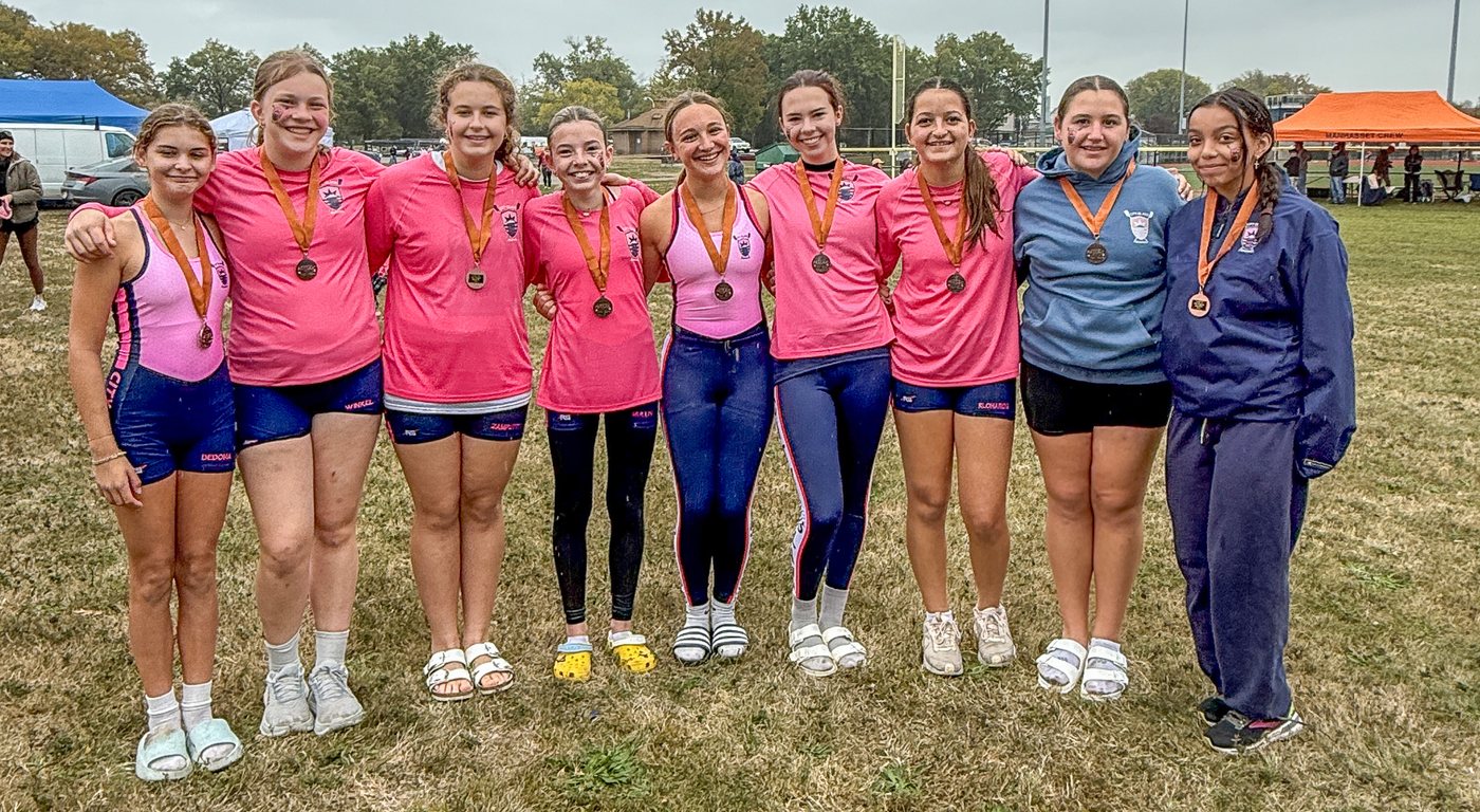 A group of girls in pink on the regatta field, medals around their necks