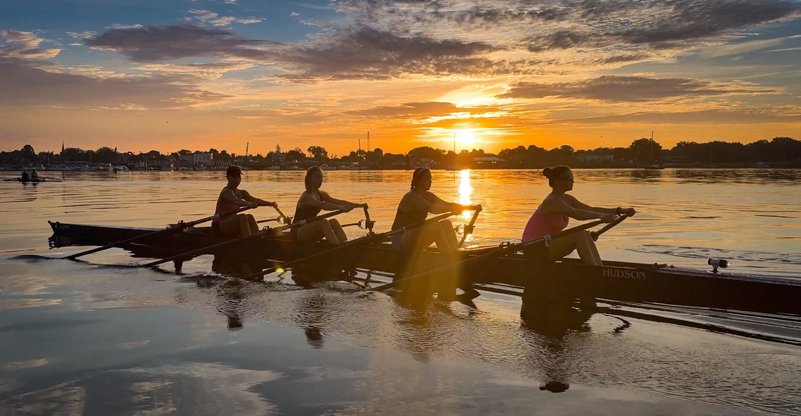 Two quads silhouetted against the Wednesday sunrise, water like glass