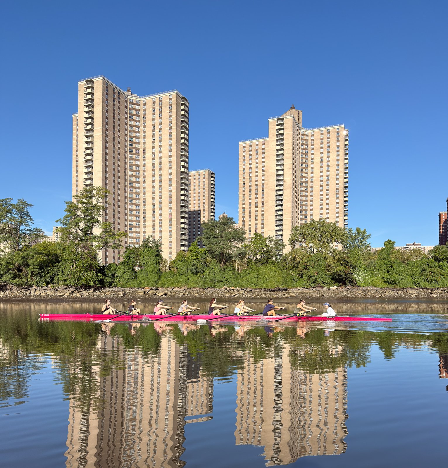 An eight on glassy water with the Co-op City towers reflected behind it