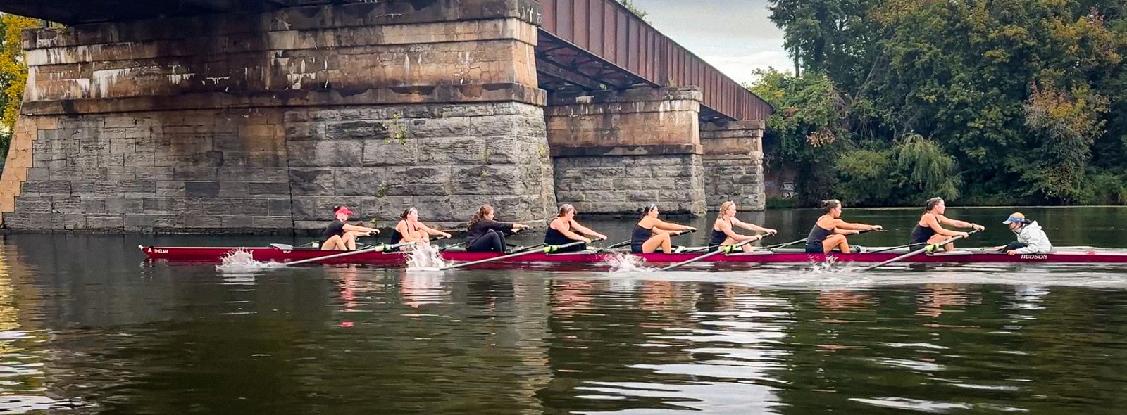 An eight passing under the stone bridge on the course
